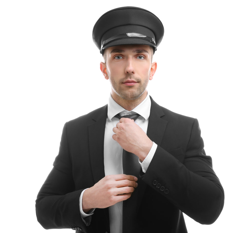 Young chauffeur adjusting tie on white background
